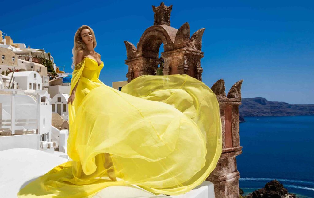 Yellow flying dress girl in Santorini